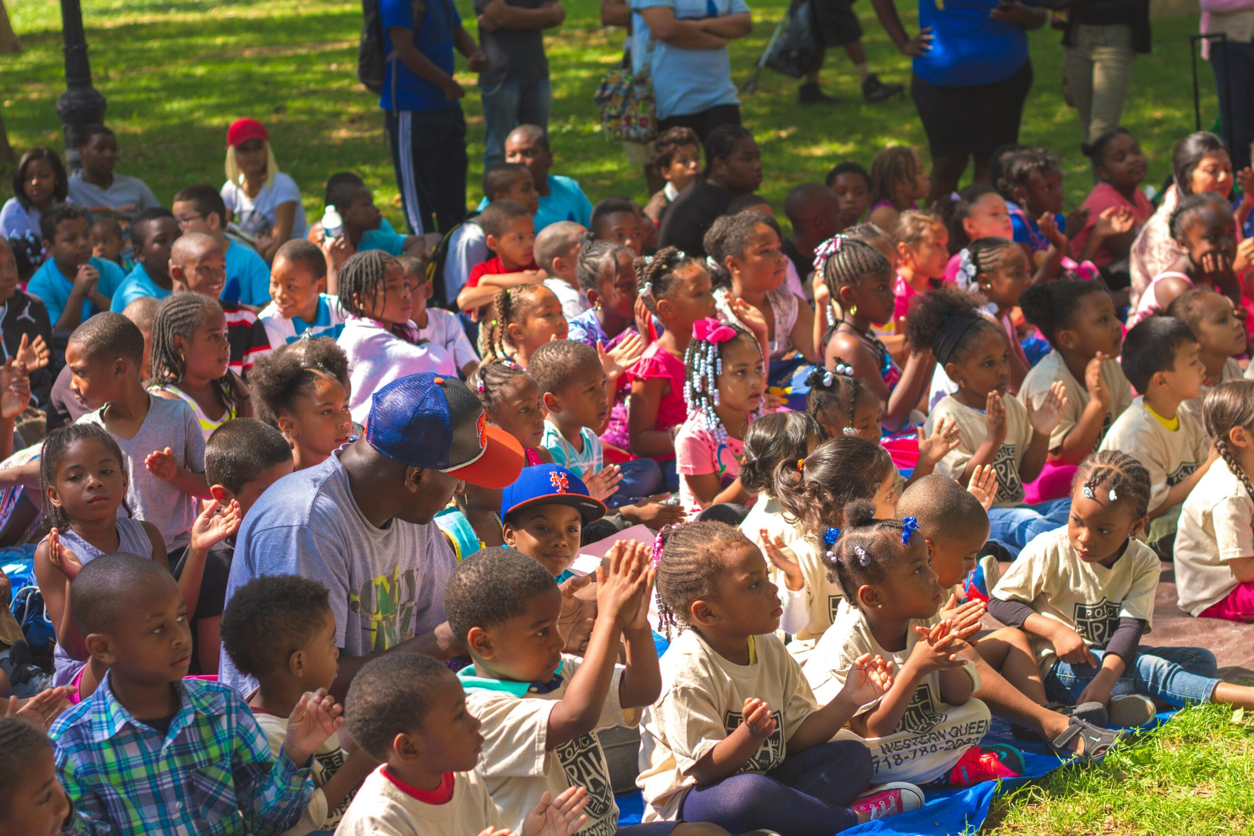 A diverse group of children gathered outdoors for a fun event, engaging in togetherness and joy.